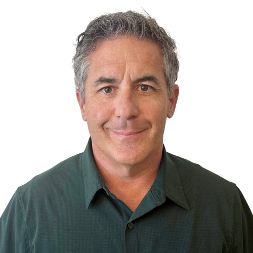 Portrait of a man with short gray hair, wearing a dark green shirt, smiling at the camera against a white background.